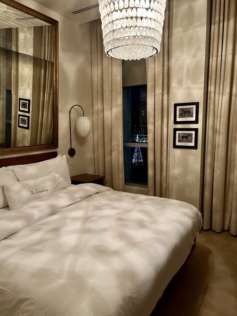 The Signature King Room at The Dewberry Charleston with king bed and large windows overlooking Marion Square.