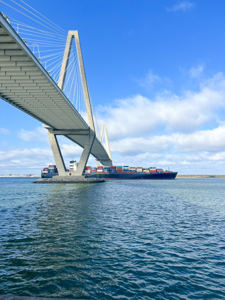 ravenel bridge in charleston seen from below as a container ship comes into port below the bridge