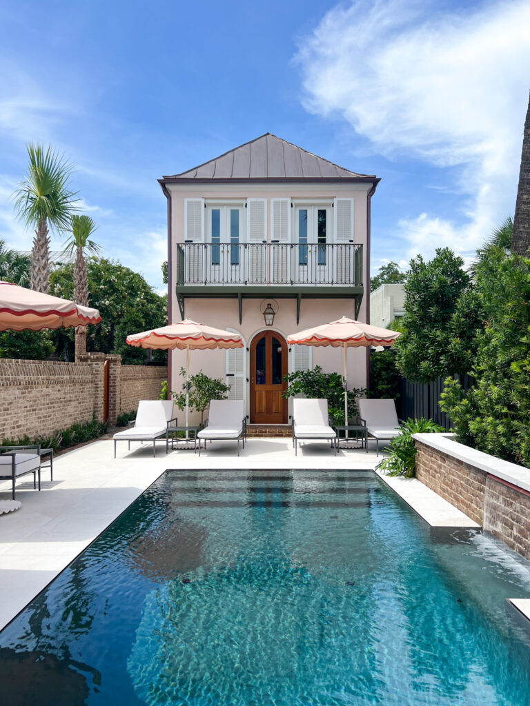 A charming pool house with pool, chairs and umbrellas at 86 Cannon boutique hotel in Charleston.