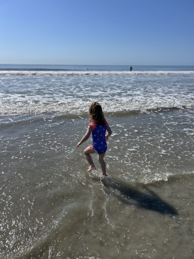 toddler at folly beach splashing in waves